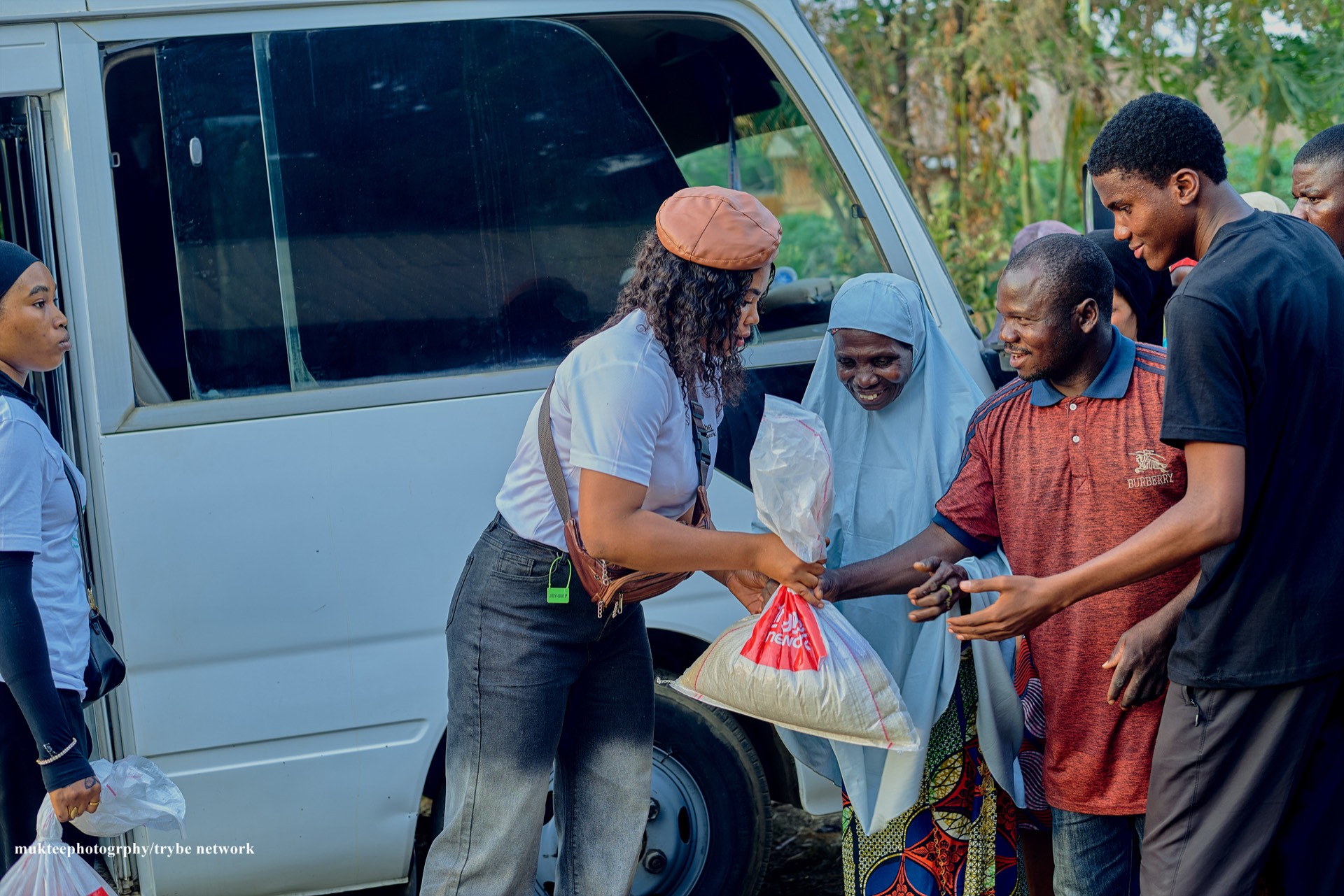 A Tryybe team member handing a relief package to an elderly woman