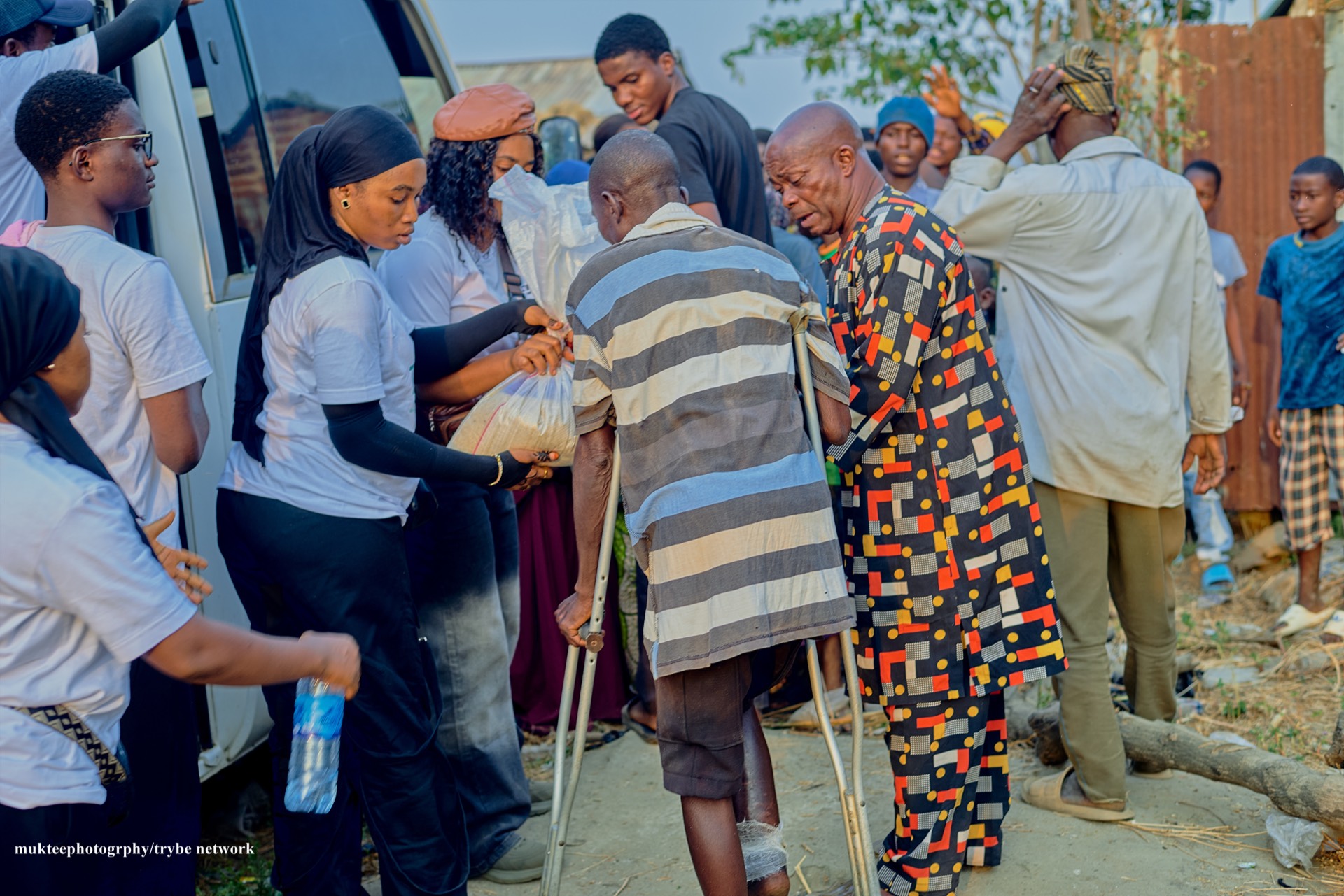 A man with crutches receiving relief material from the Tryybe team