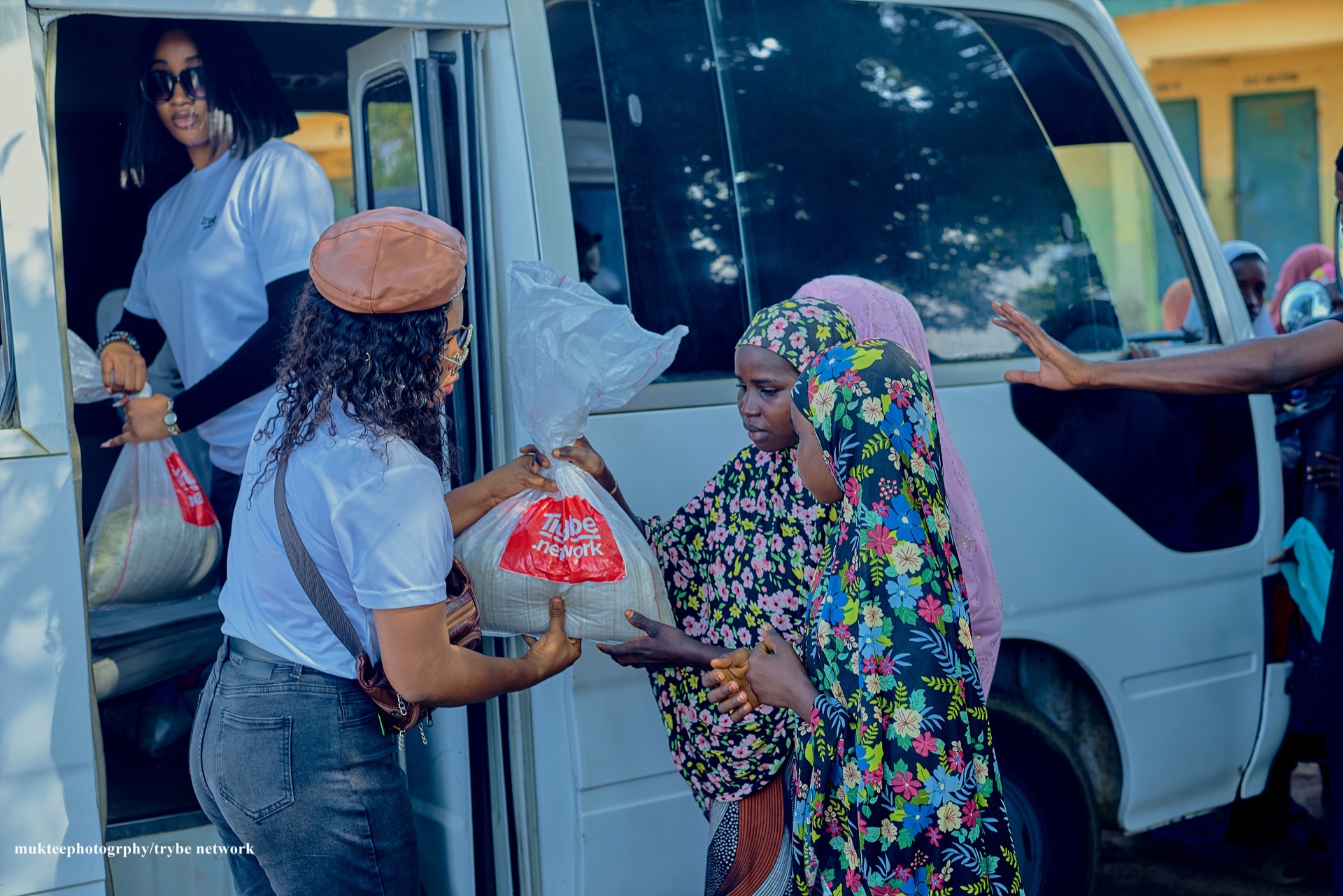 Tryybe members handing relief materials to young girls